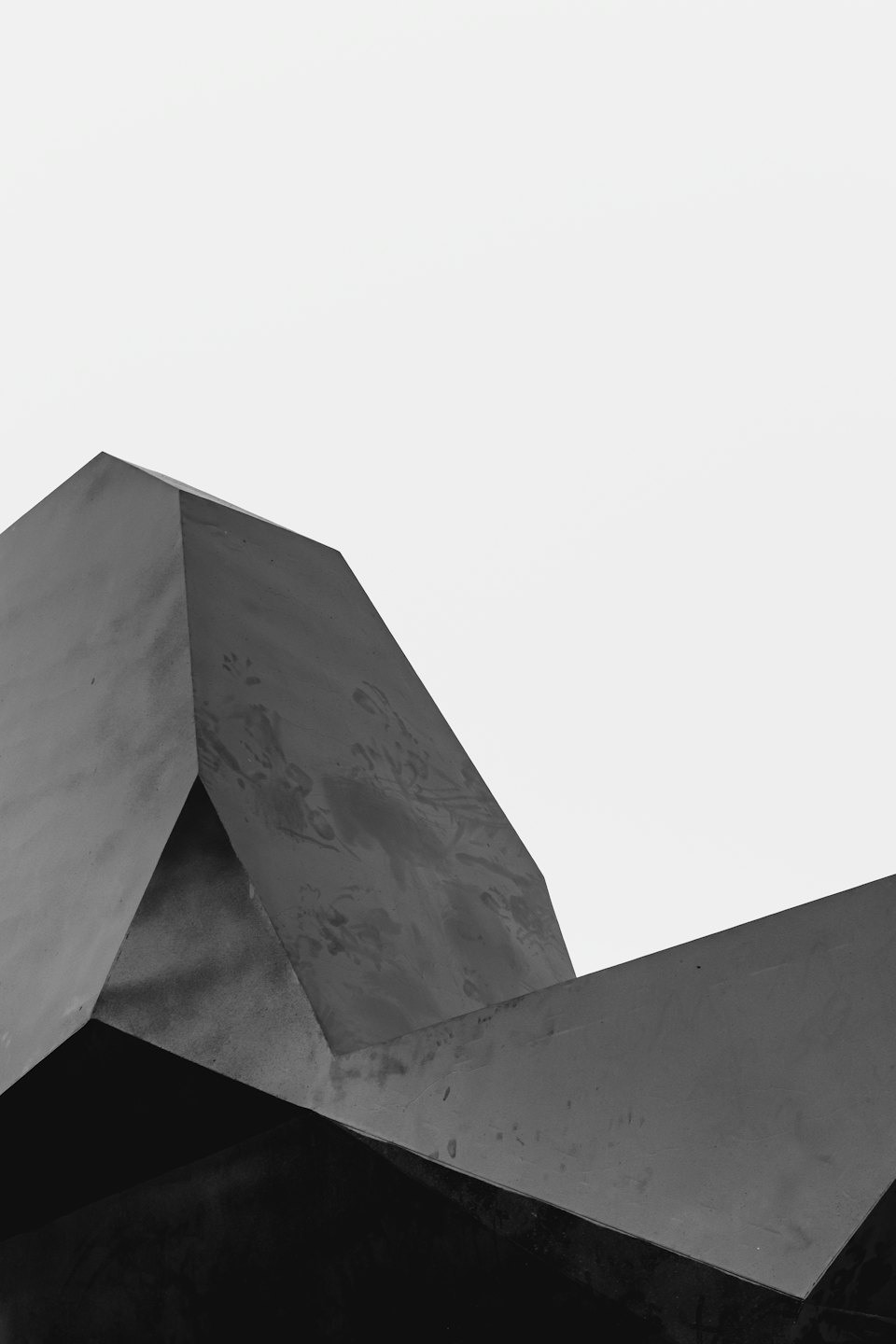 Forme geometriche di materiale scuro e ruvido su sfondo bianco.