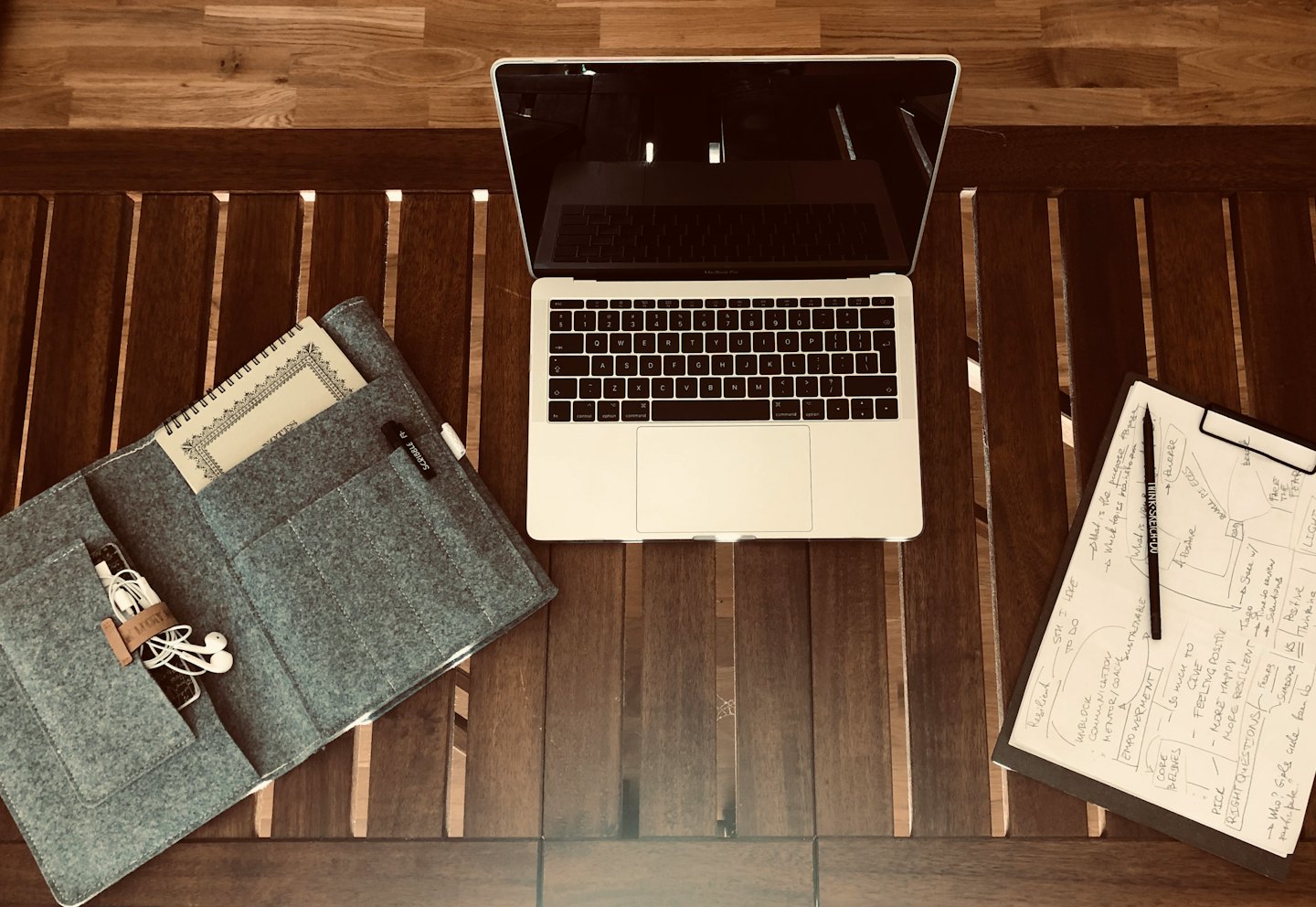 Computer portatile e cancelleria disposti su una scrivania di legno.